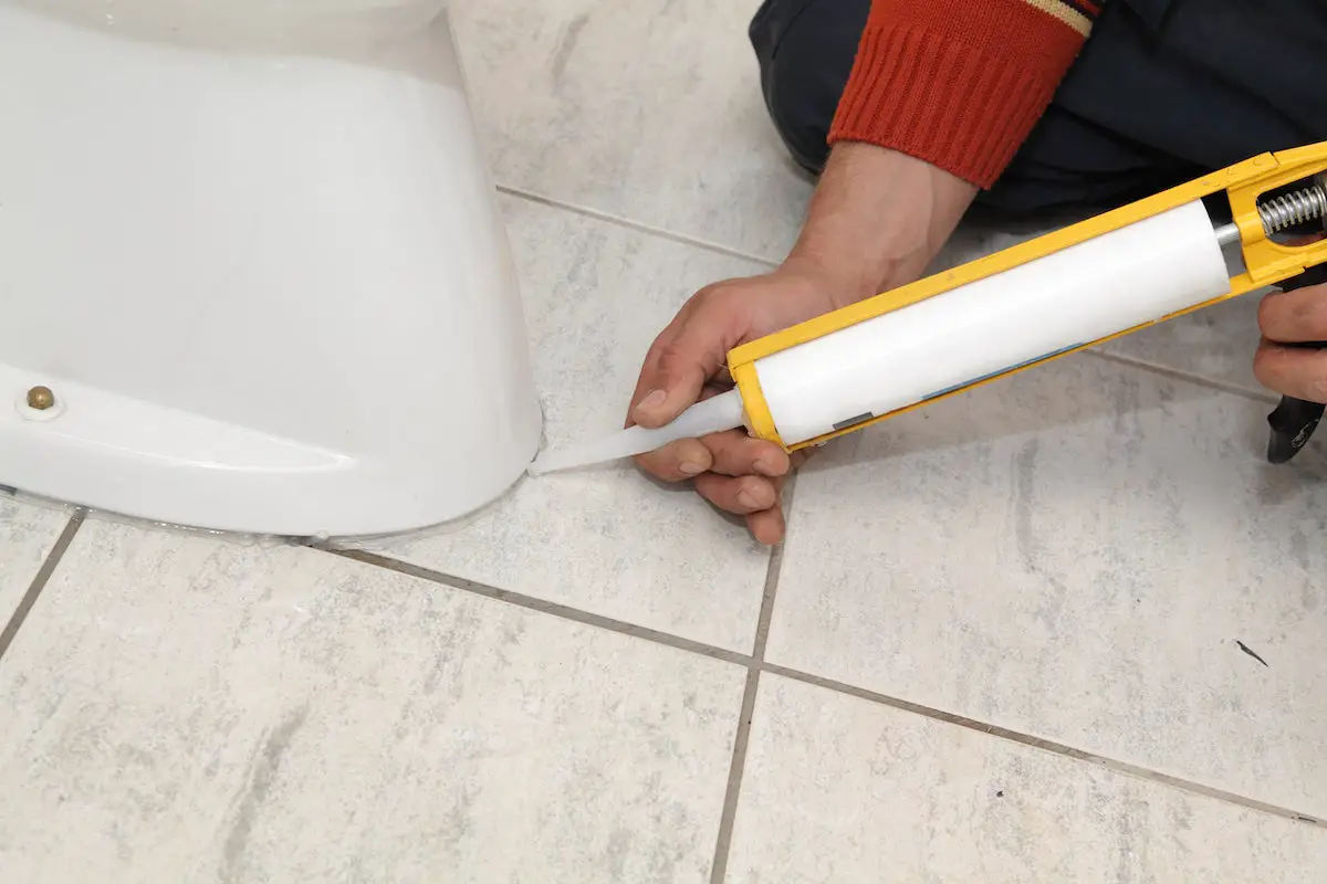 Caulk prevents water from seeping under the toilet