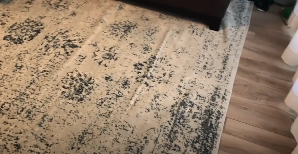 Is it possible for rugs to cause scratches on vinyl floors?