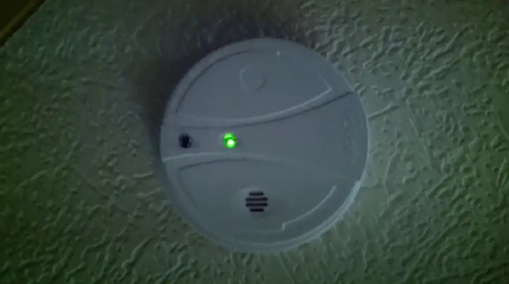 What is the reason behind the green blinking of a smoke detector?